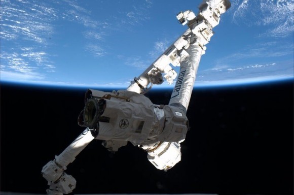 Canadarm pictured through a winow aboard the ISS will be used to grapple the SpaceX Dragon after planned March 1 liftoff.  Credit: NASA/Thomas Mashburn