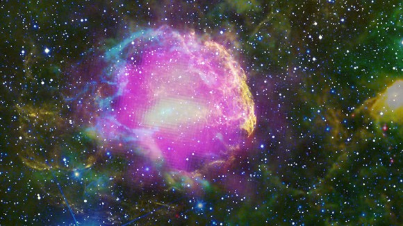 This multiwavelength composite shows the supernova remnant IC 443, also known as the Jellyfish Nebula. Fermi GeV gamma-ray emission is shown in magenta, optical wavelengths as yellow, and infrared data from NASA's Wide-field Infrared Survey Explorer (WISE) mission is shown as blue (3.4 microns), cyan (4.6 microns), green (12 microns) and red (22 microns). Cyan loops indicate where the remnant is interacting with a dense cloud of interstellar gas. Credit: NASA/DOE/Fermi LAT Collaboration, NOAO/AURA/NSF, JPL-Caltech/UCLA